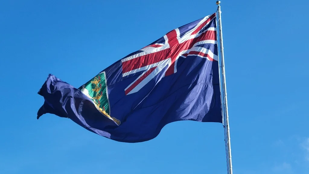Cayman Islands flag flying against a clear blue sky